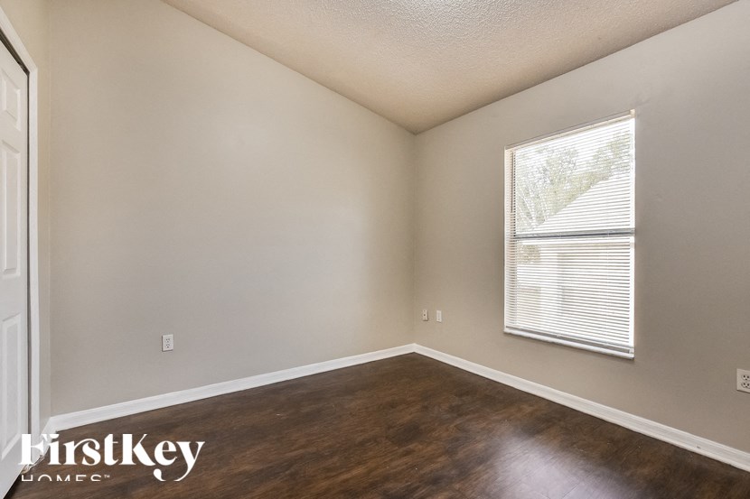 A room with a window and wooden floors.