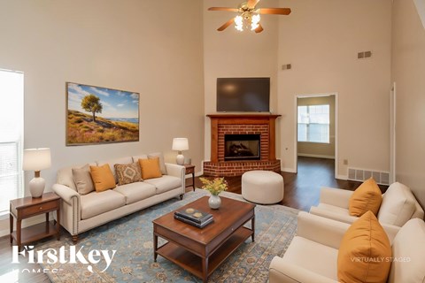 A living room with a fireplace and a painting on the wall.