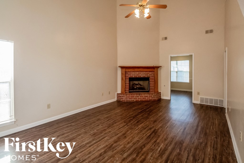 A spacious living room with a fireplace and wood flooring.
