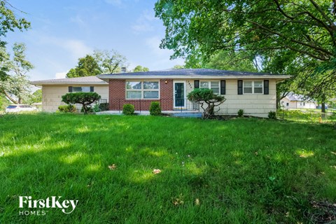 a house with a lawn and trees in front of it