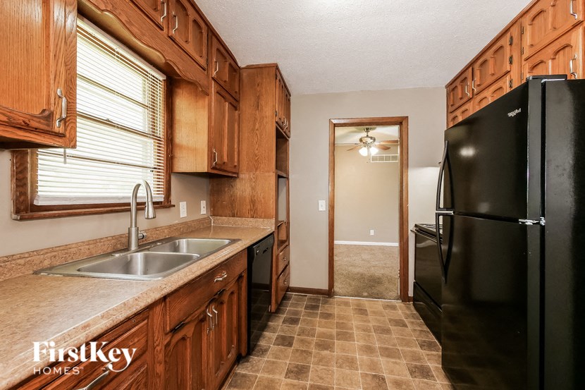a kitchen with a black refrigerator and a sink
