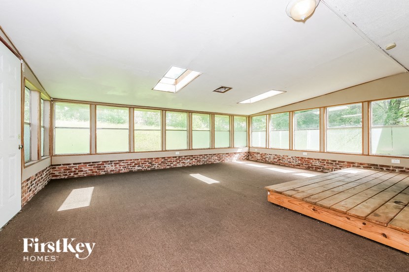 a room with windows and a wooden bench in it