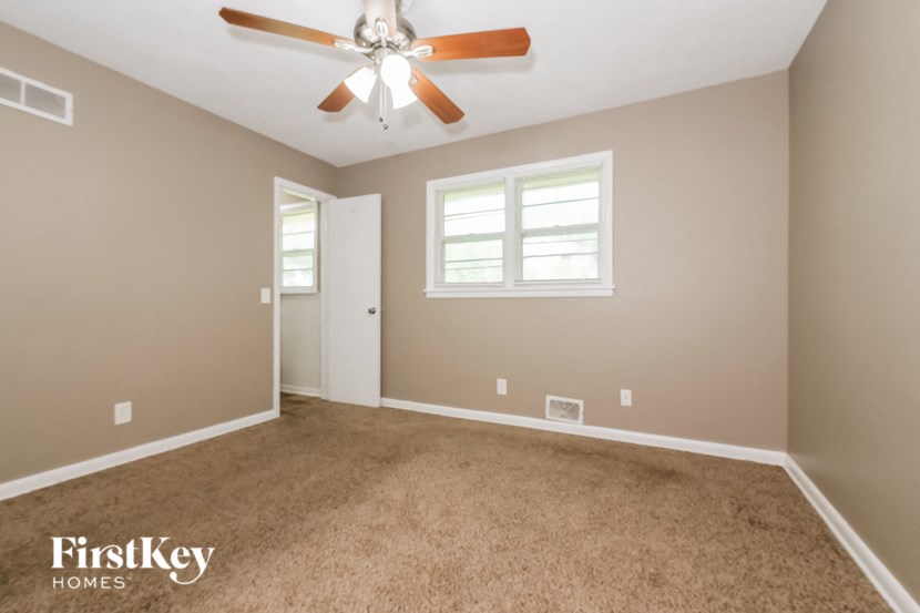 an empty room with a ceiling fan and a window