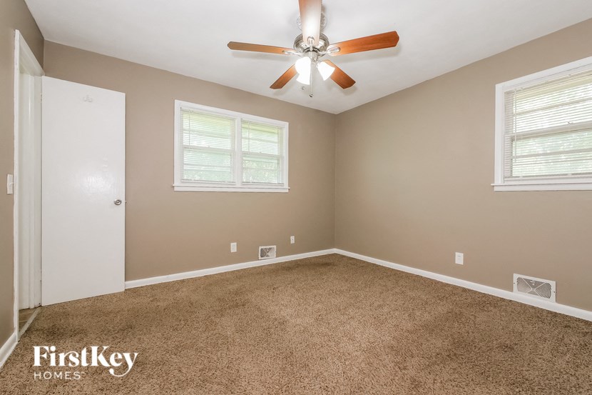 a bedroom with carpet and a ceiling fan