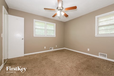 a bedroom with carpet and a ceiling fan