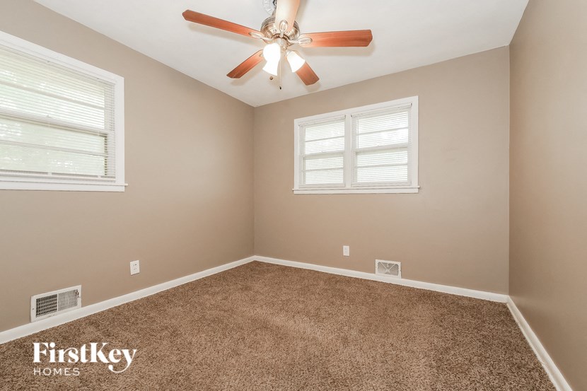 the master bedroom has a ceiling fan and a carpeted floor