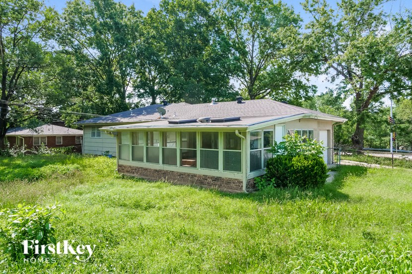 a small house in a grassy yard with trees