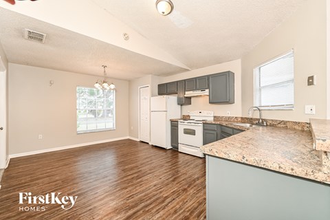 A kitchen with wooden floors and granite countertops.