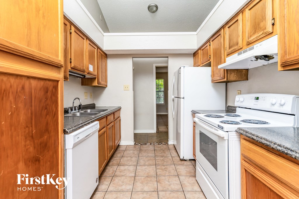 a kitchen with white appliances and wooden cabinets