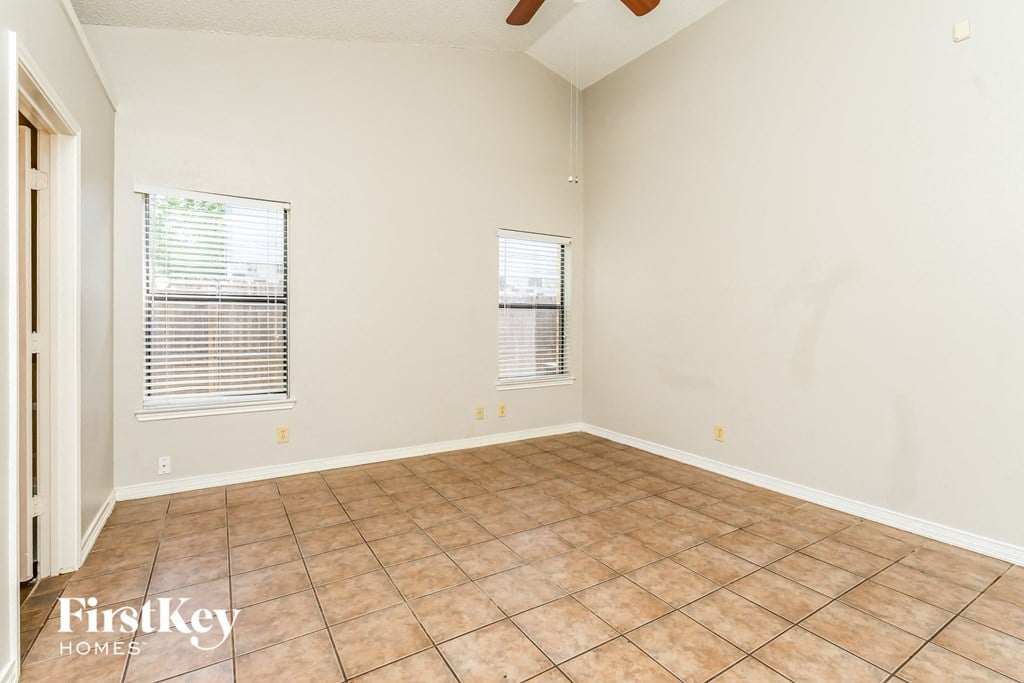 the living room of an empty home with tile flooring