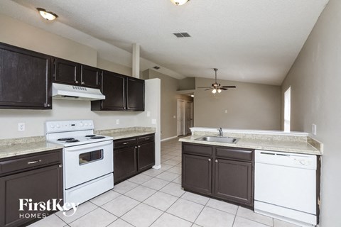 A kitchen with white appliances and black cabinets.