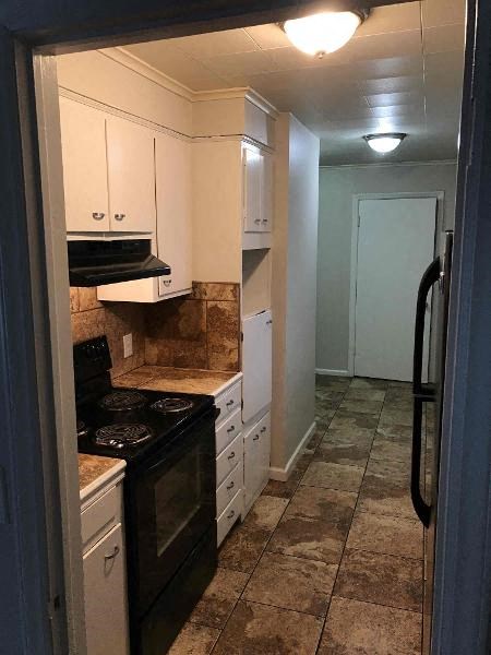 a kitchen with a black stove and white cabinets