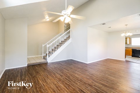 a living room with hardwood flooring and a ceiling fan