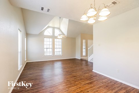 an empty living room with hardwood flooring and a window