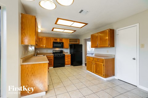 a kitchen with wooden cabinets and a white tile floor