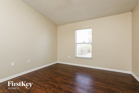a living room with wood floors and a window