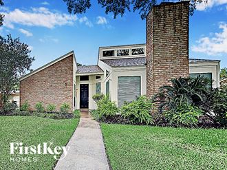 a small brick house with a sidewalk in front of it
