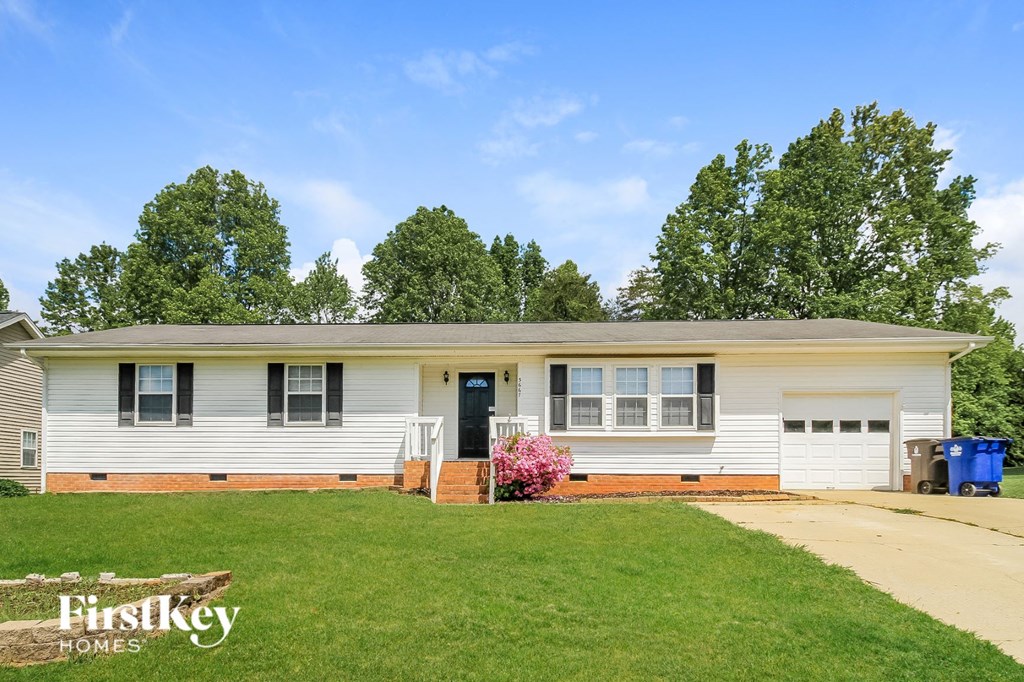 a white house with a green lawn and trees