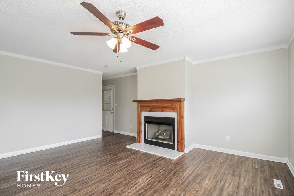a living room with a fireplace and a ceiling fan