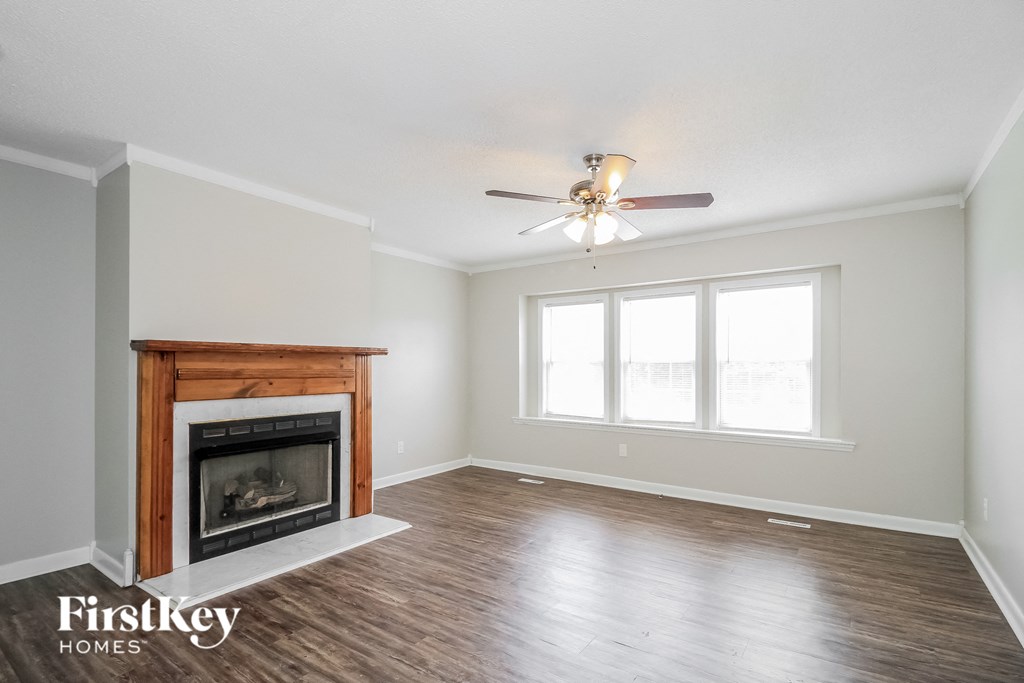 a living room with a fireplace and a ceiling fan