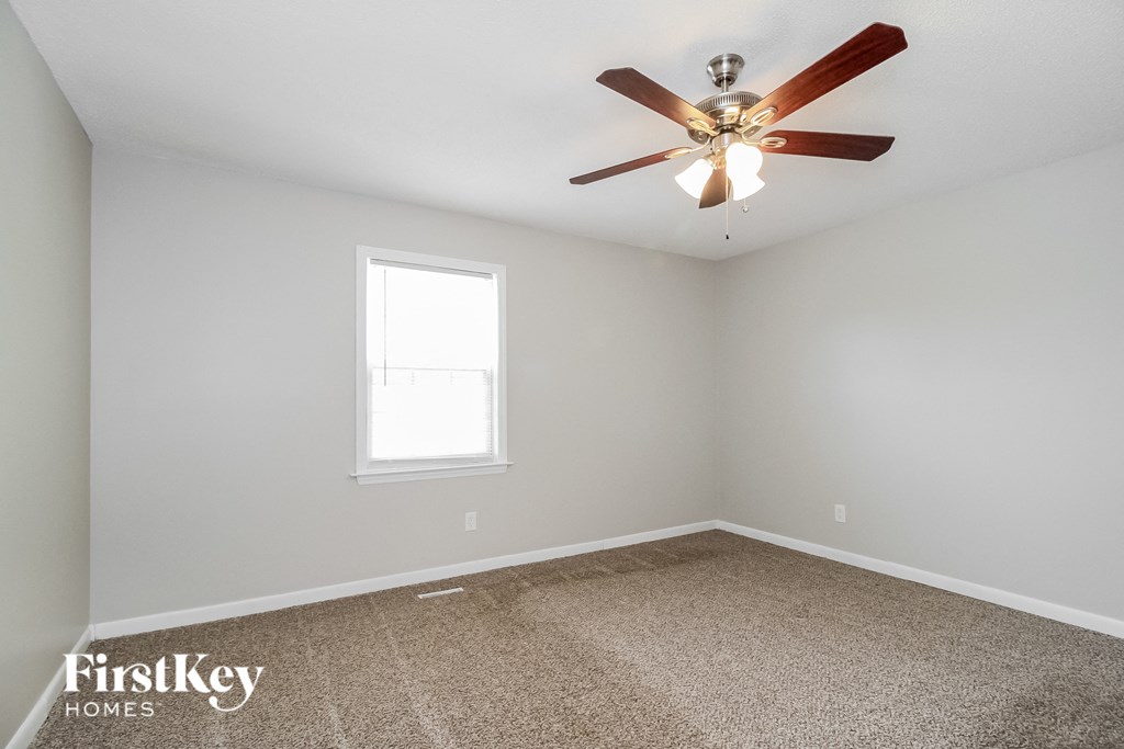 the master bedroom has a ceiling fan and a carpeted floor