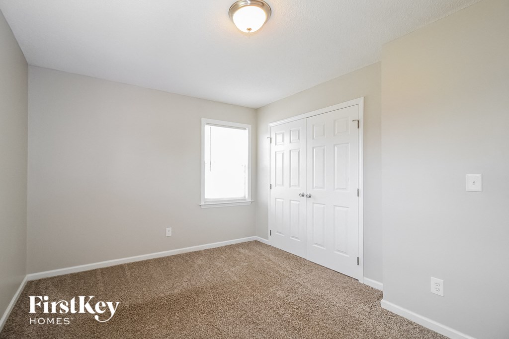 a bedroom with a carpeted floor and a white door