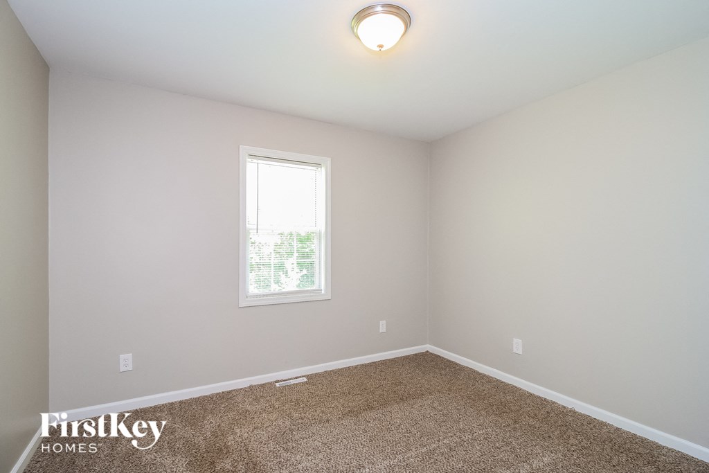 a bedroom with a carpeted floor and a window