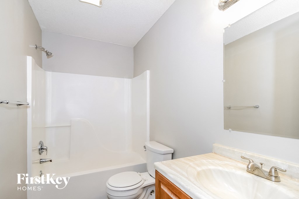 a bathroom with a toilet and a sink and a mirror