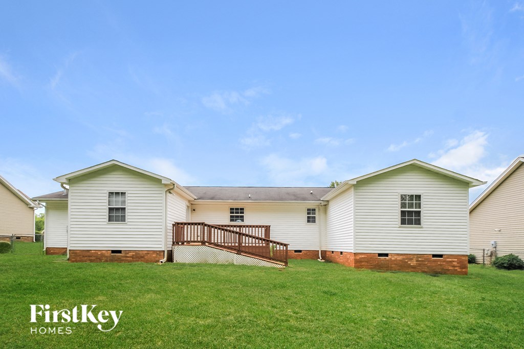 a large white house with a deck in the grass