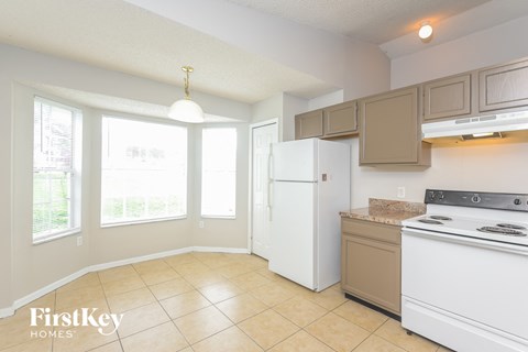 A kitchen with a white refrigerator and a white stove top oven.