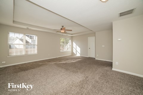 a living room with carpet and a ceiling fan