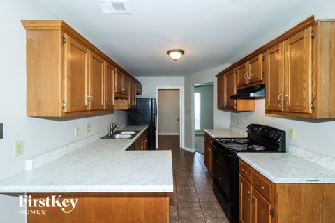 A kitchen with wooden cabinets and a black refrigerator.