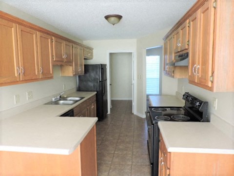 A kitchen with wooden cabinets and black appliances.