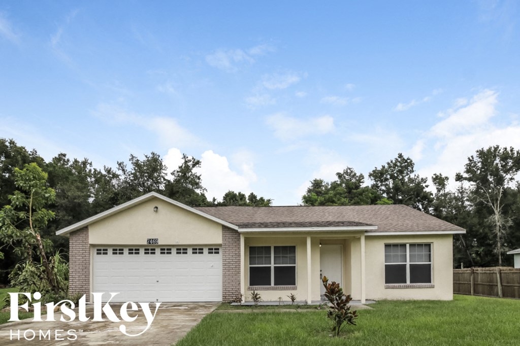 a home with a white garage door and a lawn