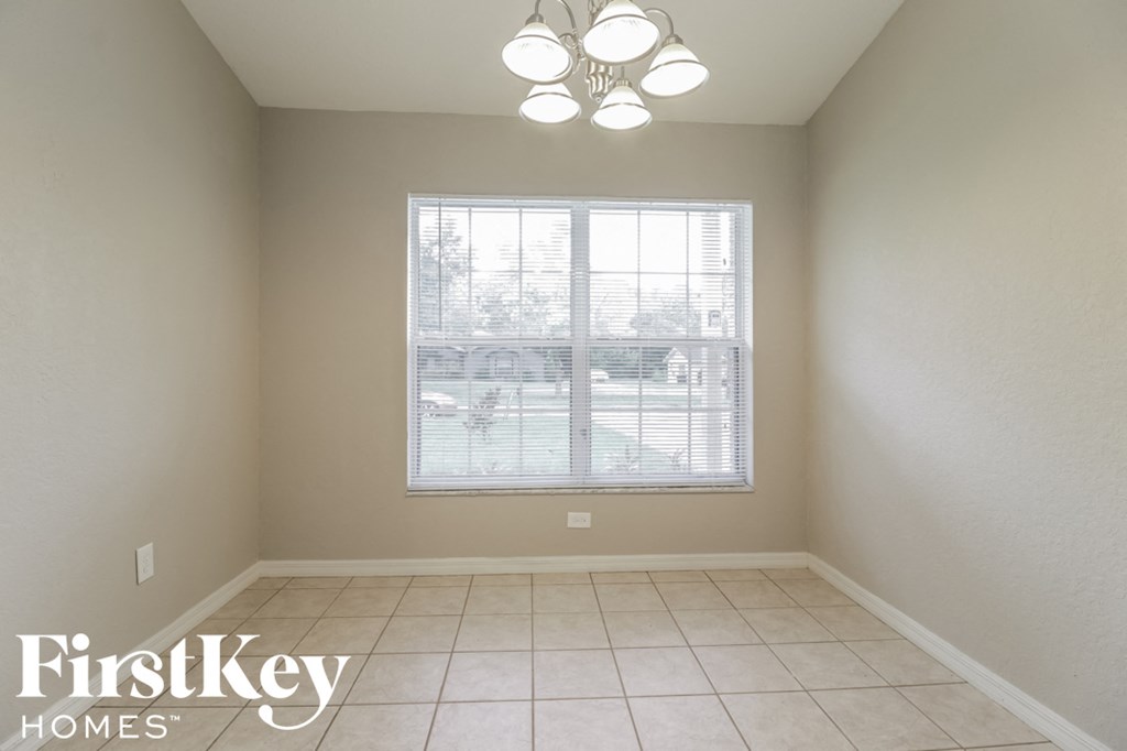 a dining room with a large window and a tiled floor