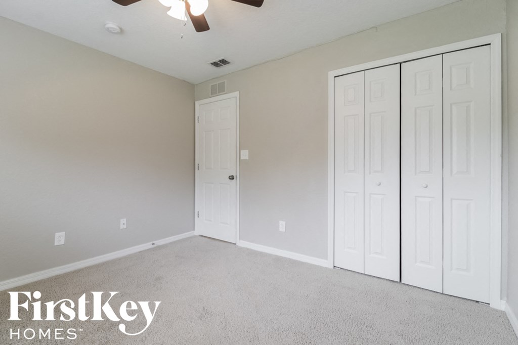 a bedroom with two closets and a carpeted floor