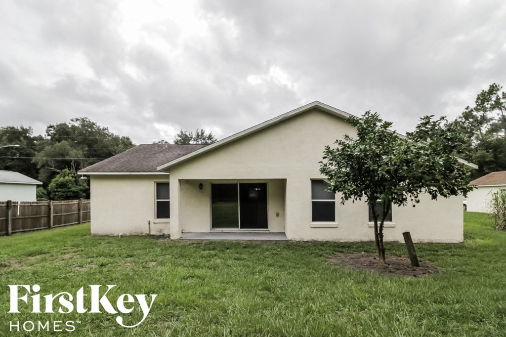 a white house with a yard and a tree