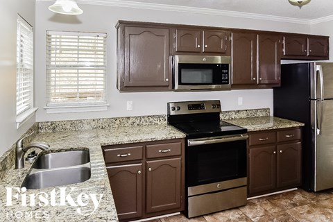 a kitchen with granite counter tops and black appliances