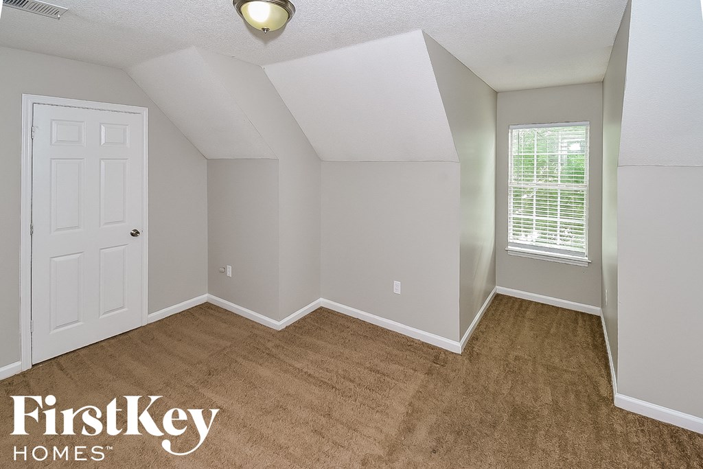 an empty room with a white door and a window