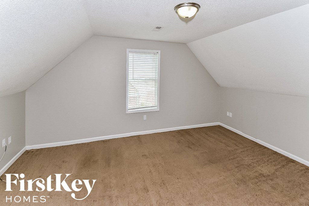 a bedroom with a carpeted floor and a window