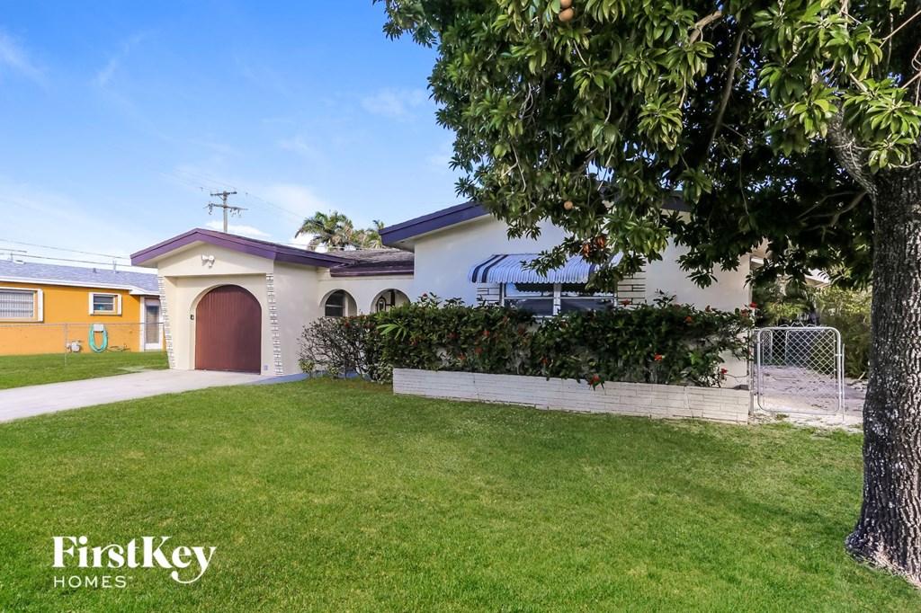a house with a yard and a fence and a garage