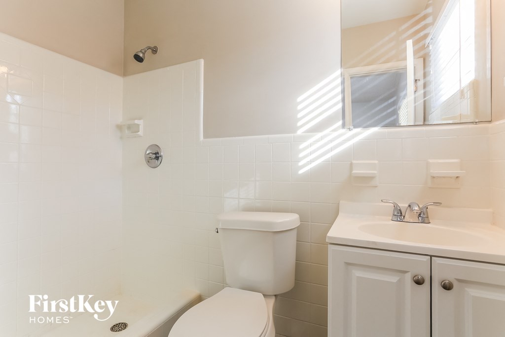 a white bathroom with a toilet and a sink