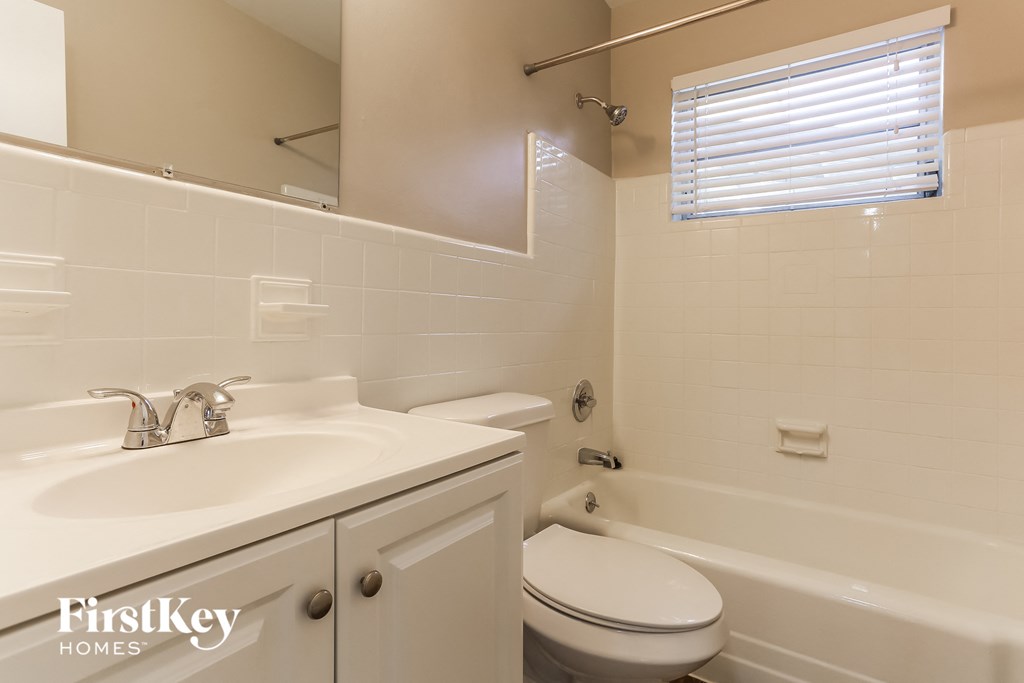 a white bathroom with a sink toilet and tub