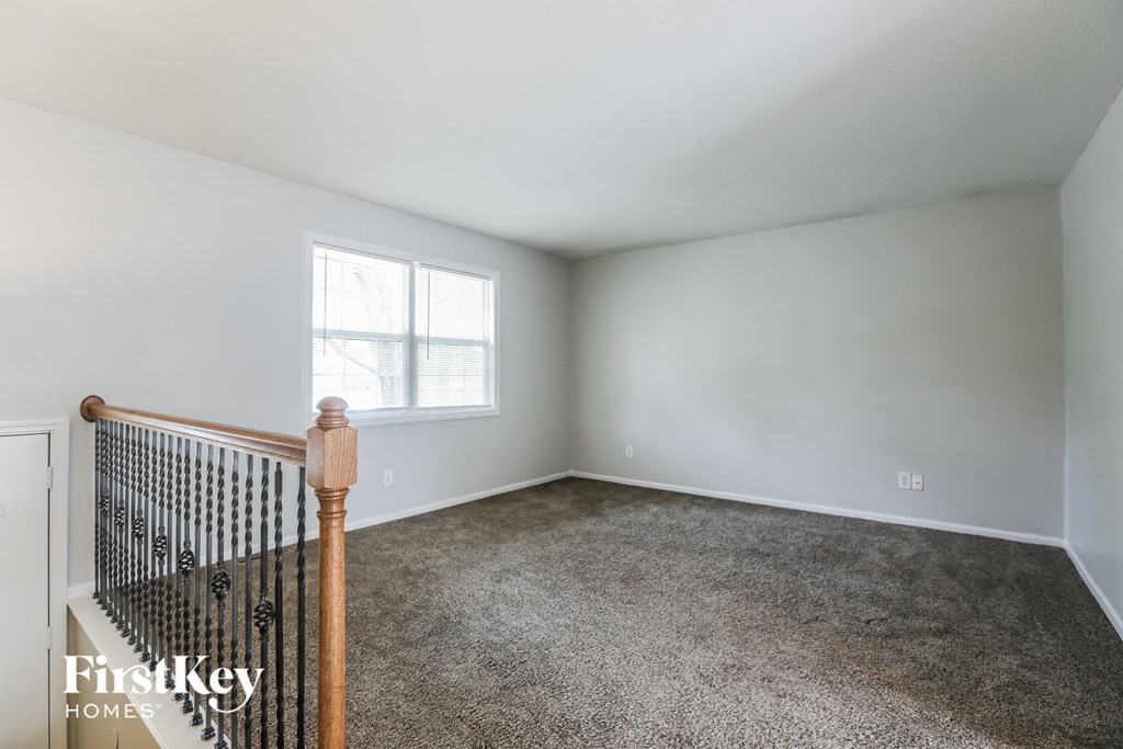 A room with a carpeted floor and a window.