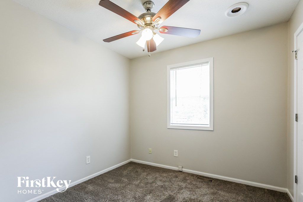 A room with a ceiling fan and a window.