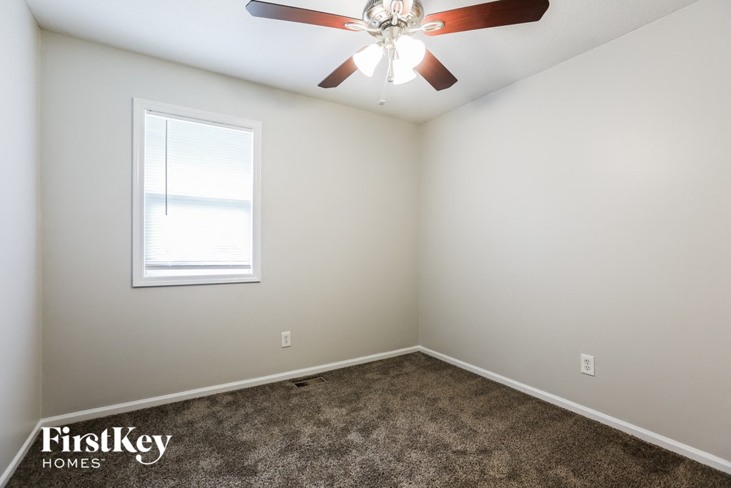 A room with a ceiling fan and a window.