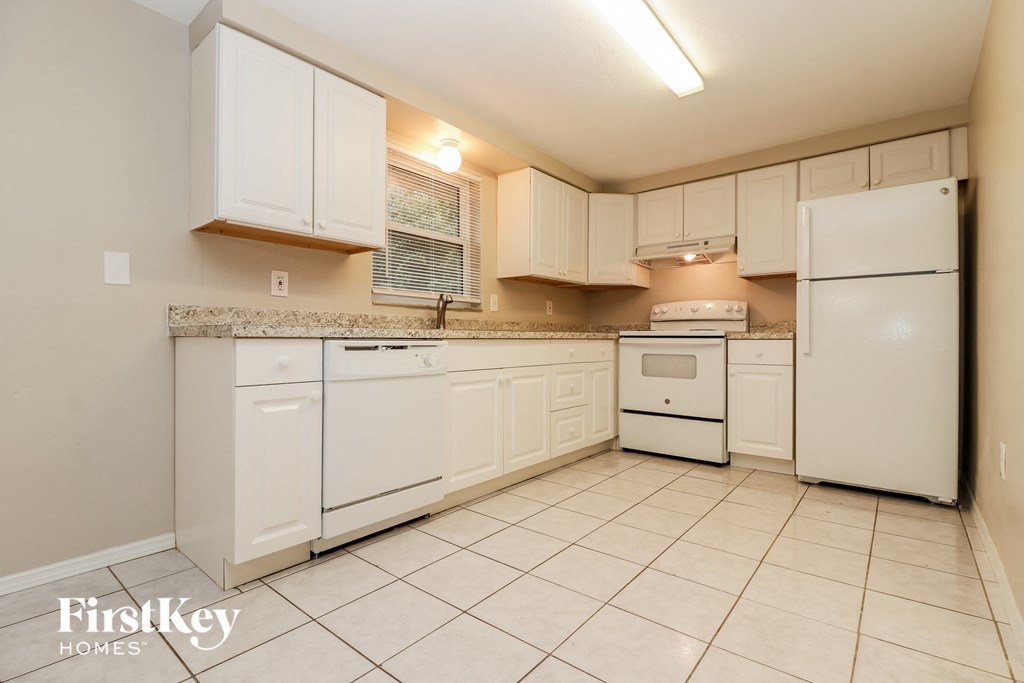 a white kitchen with white appliances and white cabinets