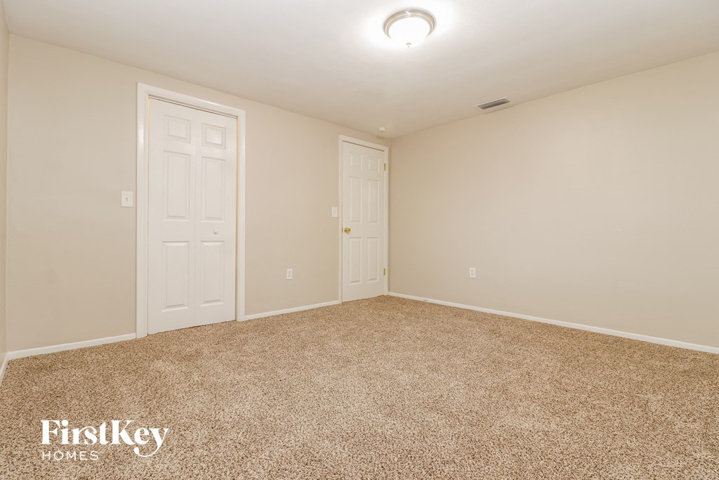 a bedroom with a carpeted floor and two doors
