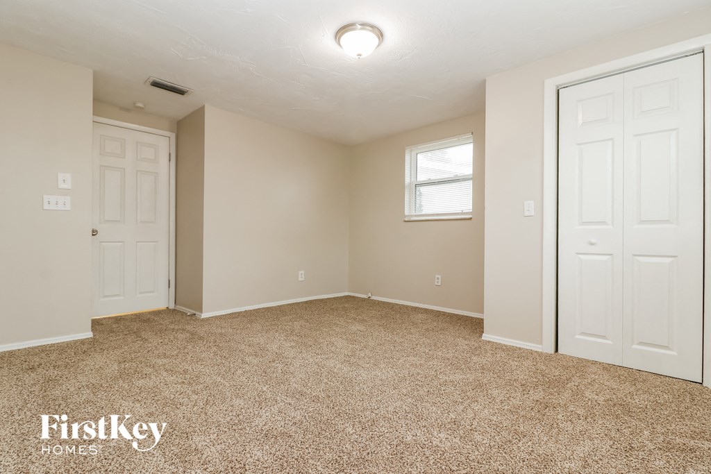 a bedroom with two white doors and a carpeted floor