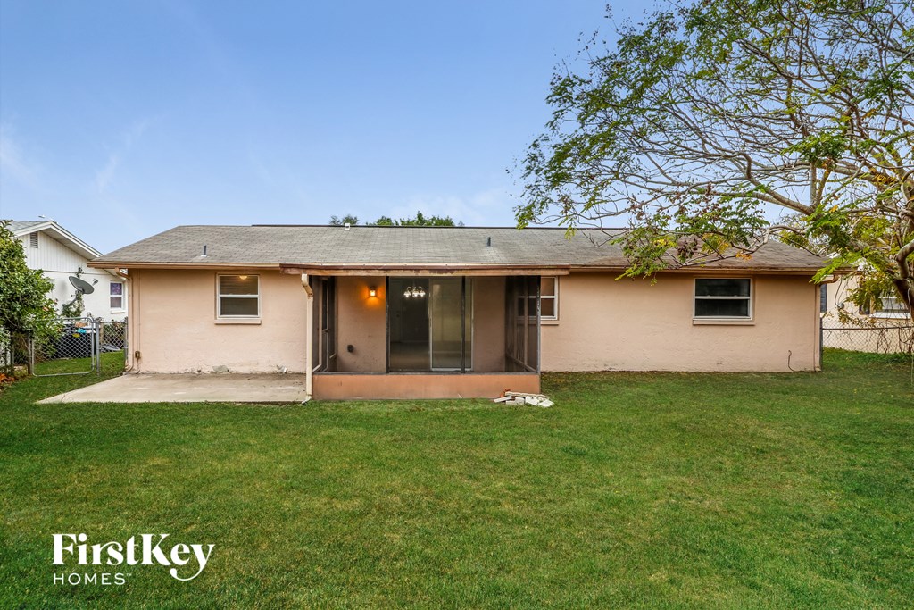 a pink house with a yard and a tree